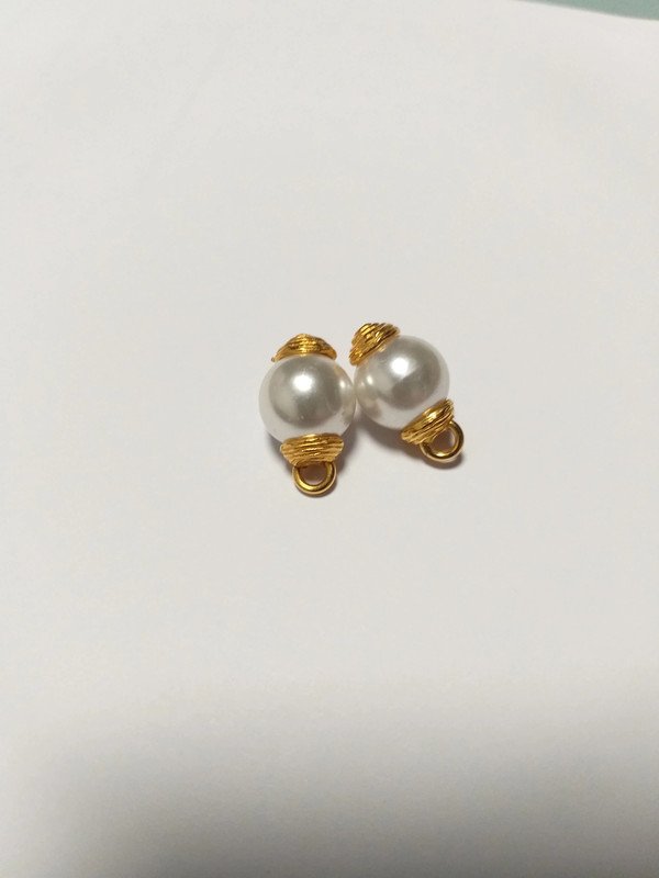 Bouton doré et perle.